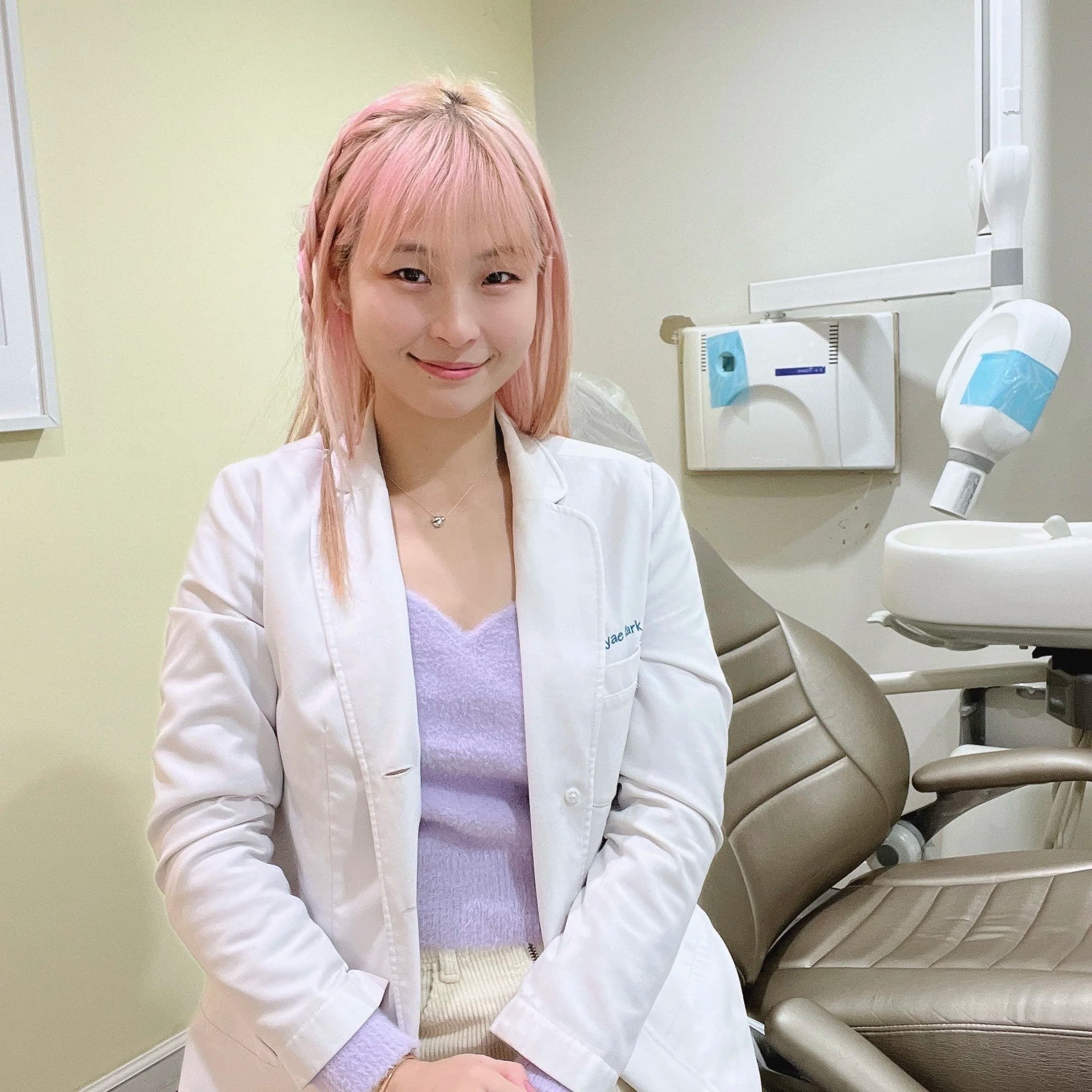 Dental professional in a white coat sitting in a dental treatment room at Sweet Tooth Dental Care.