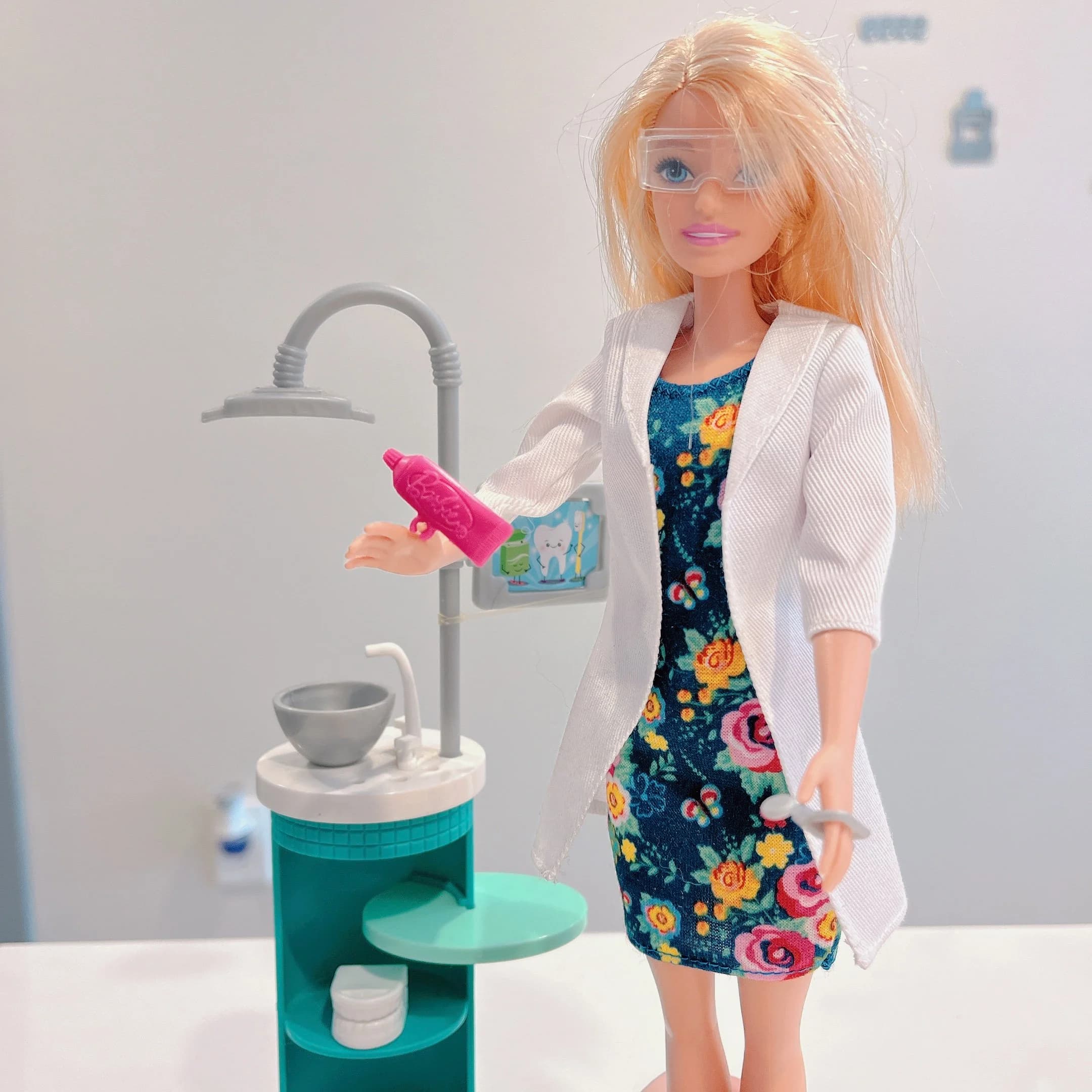 Child-friendly toy dentist display with a doll, dental tools, and a miniature dental sink.